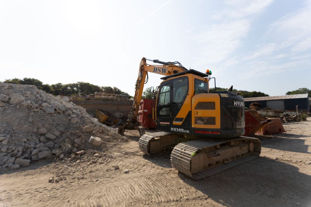 _33A7310 Excavator sorting through aggregates at DSW's yard in St Dennis, Cornwall